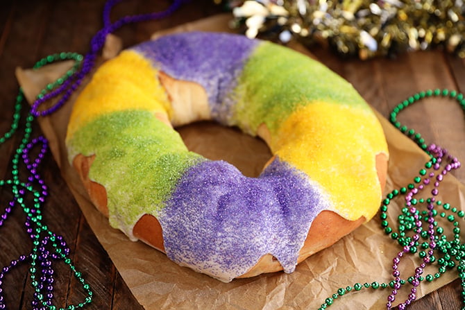 King Cake on brown paper with  Mardi Gras beads