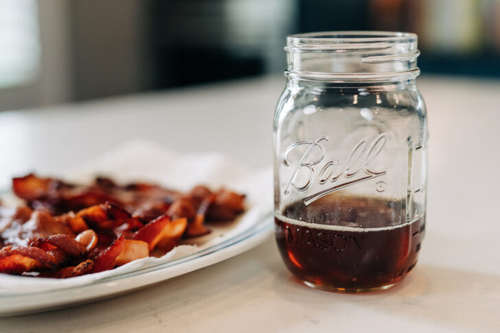 plate of bacon with jar of bacon grease.