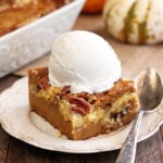Pumpkin Spice Dump Cake on white serving dish with ice cream on top