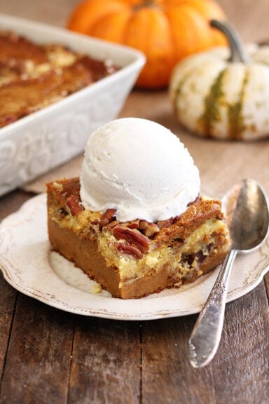 Pumpkin Spice Dump Cake on white serving dish with ice cream on top