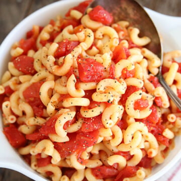 Macaroni and tomatoes served in white bowl