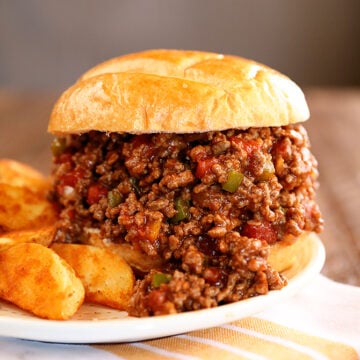 Creole Sloppy Joes  on a white plate with potato wedges