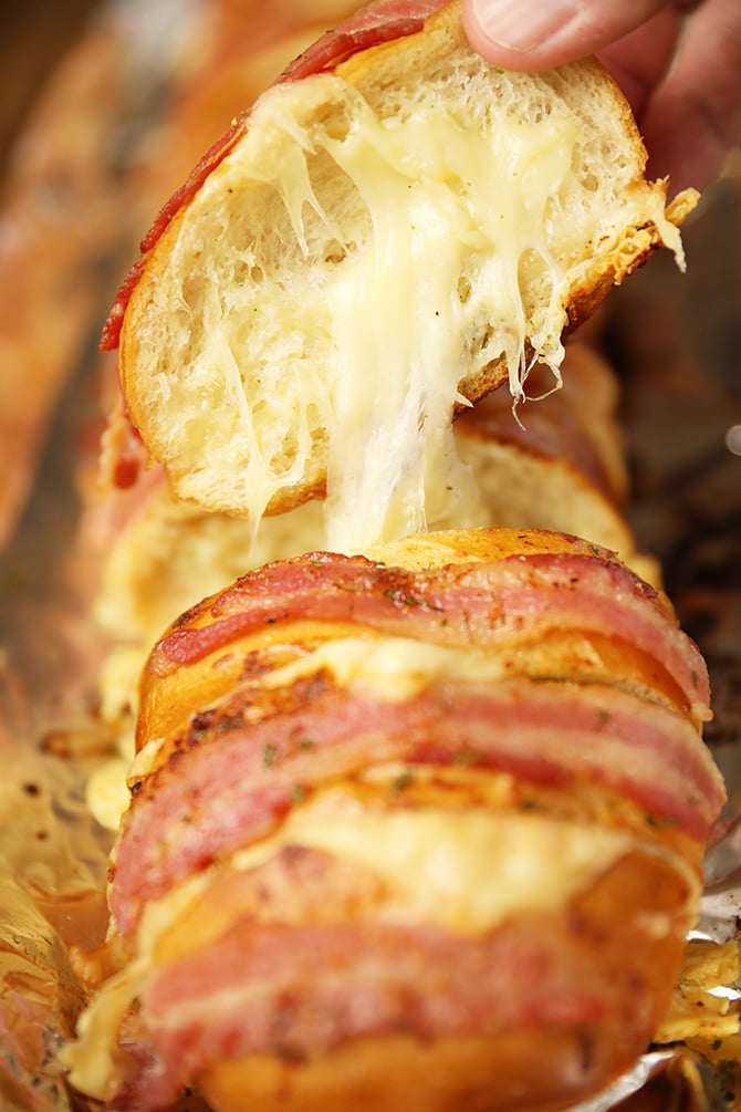 Slice of Cheesy Swiss Bacon Ranch Bread with cheese pull