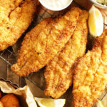 Pieces of Lemon Pepper Fried Catfish with lemons