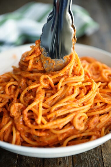 Tongs swirling 3-Ingredient Tomato and Boursin Pasta in a bowl.