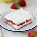 Slice of Strawberry Delight on plate with blue rim.